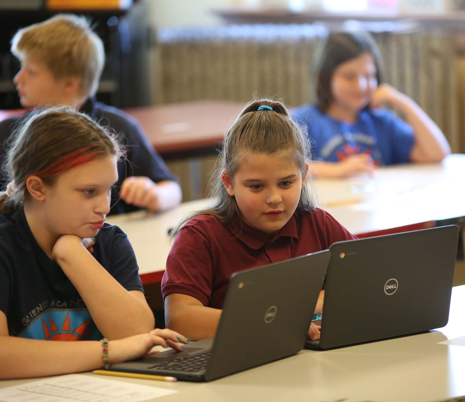 HSA Dayton Downtown student wearing headphones uses a laptop in class